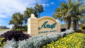 A sign for Amati Coast Resort with a clear view of the surrounding landscaping.