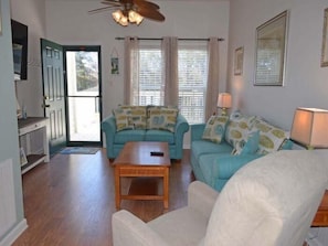 A living room with a sofa set, a coffee table, and a ceiling fan. - Tucked Inn 2.0 - Walk to Beach Triplex in Surfside Beach (Surfside Beach)