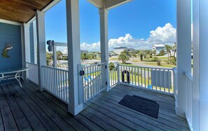 A covered porch with a view of a swimming pool and a residential area. - Buckeye Heaven - Second Row in Garden City Beach (Garden City Beach)
