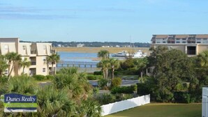 A coastal residential area with a sign for Dunes Realty, featuring a view of the beach, a marina, and several multi-story buildings. - Buckeye Heaven - Second Row in Garden City Beach (Garden City Beach)