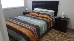 Um quarto com uma cama, duas mesas de cabeceira e uma janela.