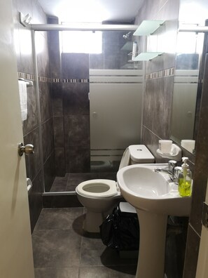 A compact bathroom with a toilet, sink, and shower area. - LIMA FLAT 1 1D (10 MIN FROM MIRAFLORES) (Lima)