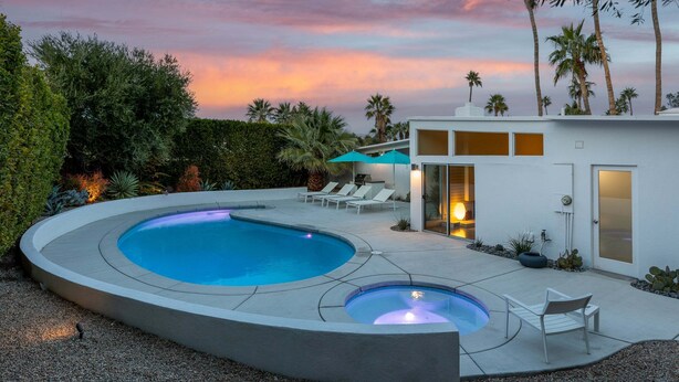 A modern pool area with a circular pool, lounge chairs, and a small outdoor kitchen. - Desert Eden – Midcentury Pool Oasis (Palm Springs)