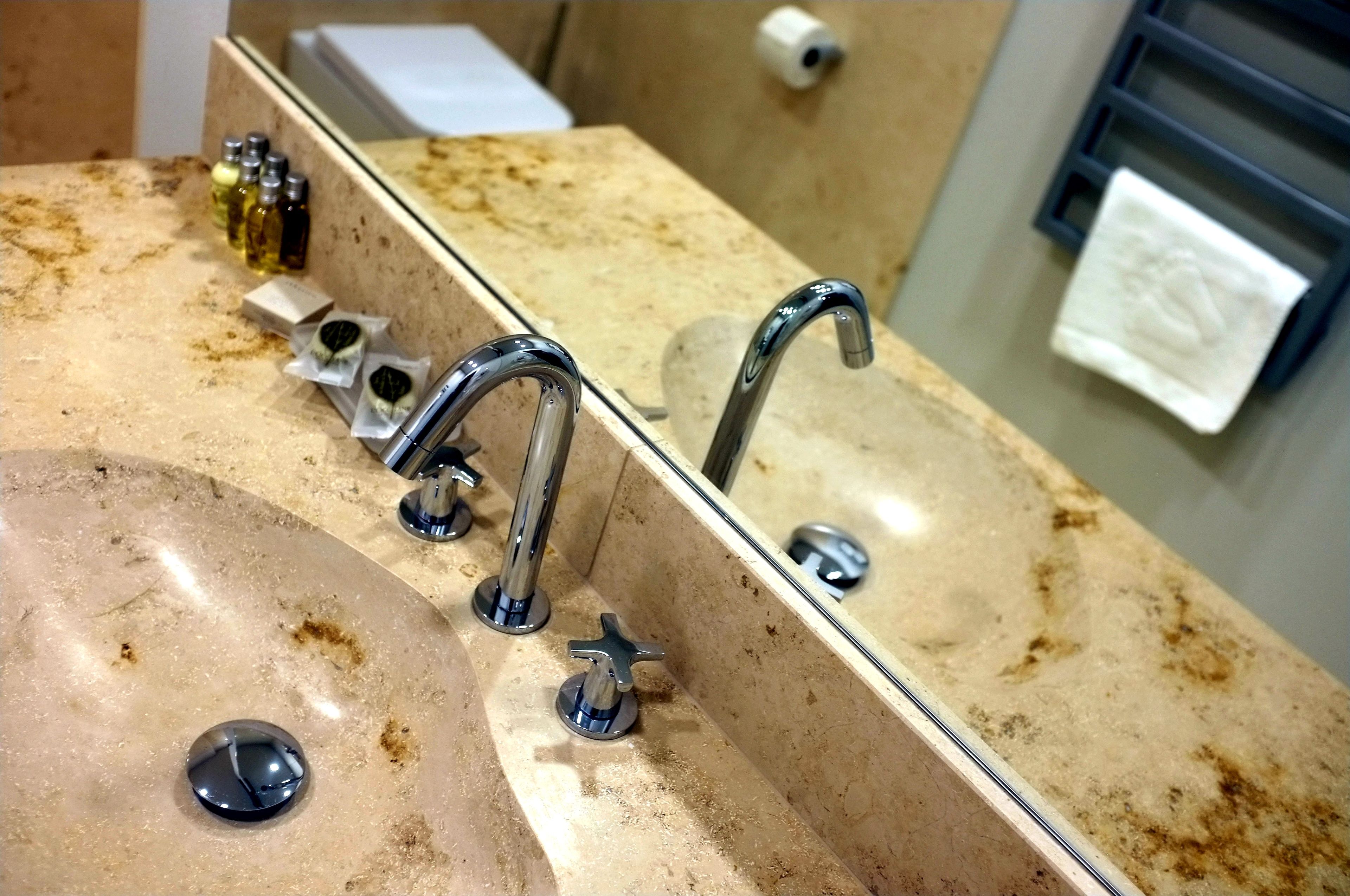 Un lavabo de salle de bain avec un miroir, un porte-serviettes et des articles de toilette.