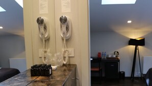 A modern bathroom with a large mirror, a sink, and two hair dryers mounted on the wall. - Dada Premium Aparthotel (Kraków)