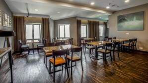 A spacious dining area with multiple tables and chairs, large windows, and a modern ceiling design. - Dada Premium Aparthotel (Kraków)