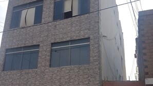 Un edificio a più piani con facciata in pietra e ampie finestre.