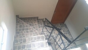 Una scala con pareti in pietra e una porta di legno.
