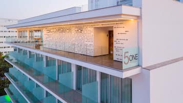 Un edificio moderno con balcón de vidrio y un letrero que dice '5ONE Restaurant'.
