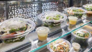 A display of various salad bowls and dressings in a restaurant setting.