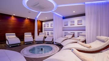 Relax in a serene spa room with a hot tub and comfortable lounge chairs.