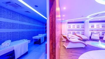Une salle de spa équipée de tables de massage, d’un espace d’accueil et d’un élément décoratif aquatique.