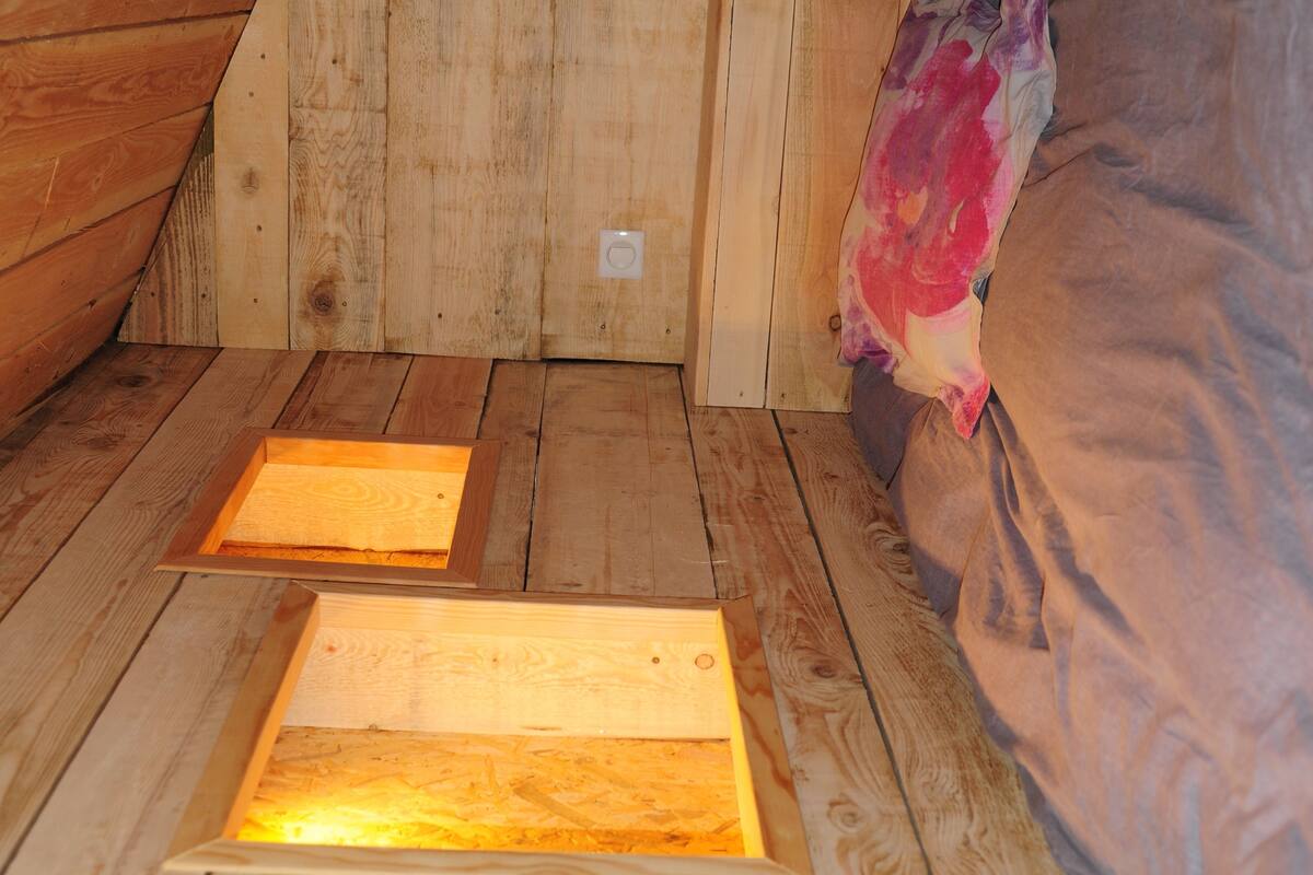 A wooden floor with a bed and a blanket.