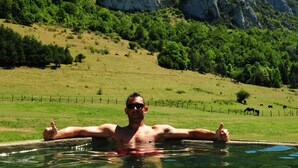 A man in a swimming pool with a mountainous landscape in the background. - Réserve Naturelle de Boussière (Gigors-et-Lozeron)