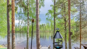 Un terrain de camping au bord du lac, équipé d’une table de pique-nique, d’un foyer et d’une jetée qui s’avance dans l’eau.