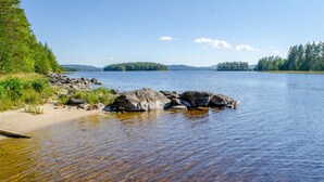 Un lac aux eaux claires, où l’on peut voir des rochers et une plage de sable.
