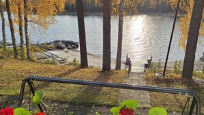 Une vue sur le lac avec un quai, des chaises et une rambarde.