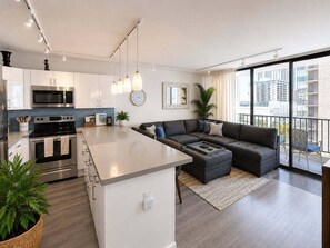 Eine moderne Wohnung mit Küche, Wohnbereich und großen Fenstern.