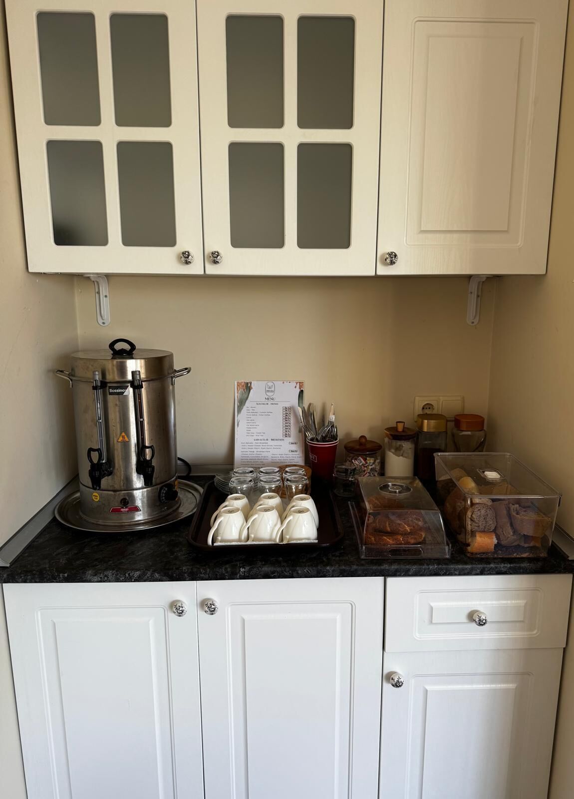 Eine Küchenzeile mit Kaffeemaschine, einer Speisekarte und unterschiedlichen Lebensmitteln.