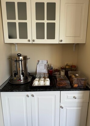 A kitchenette with a coffee maker, a menu, and various food items.