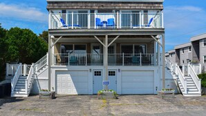 A two-story building with a balcony, white railings, and a garage. - Seven bedroom directly across street from shared/private beach (Dennis Port)