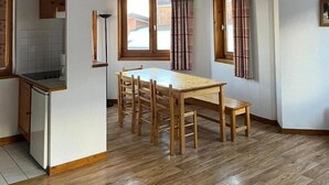 Una cocina amplia con comedor, piso de madera y una escalera que conduce a un nivel superior.