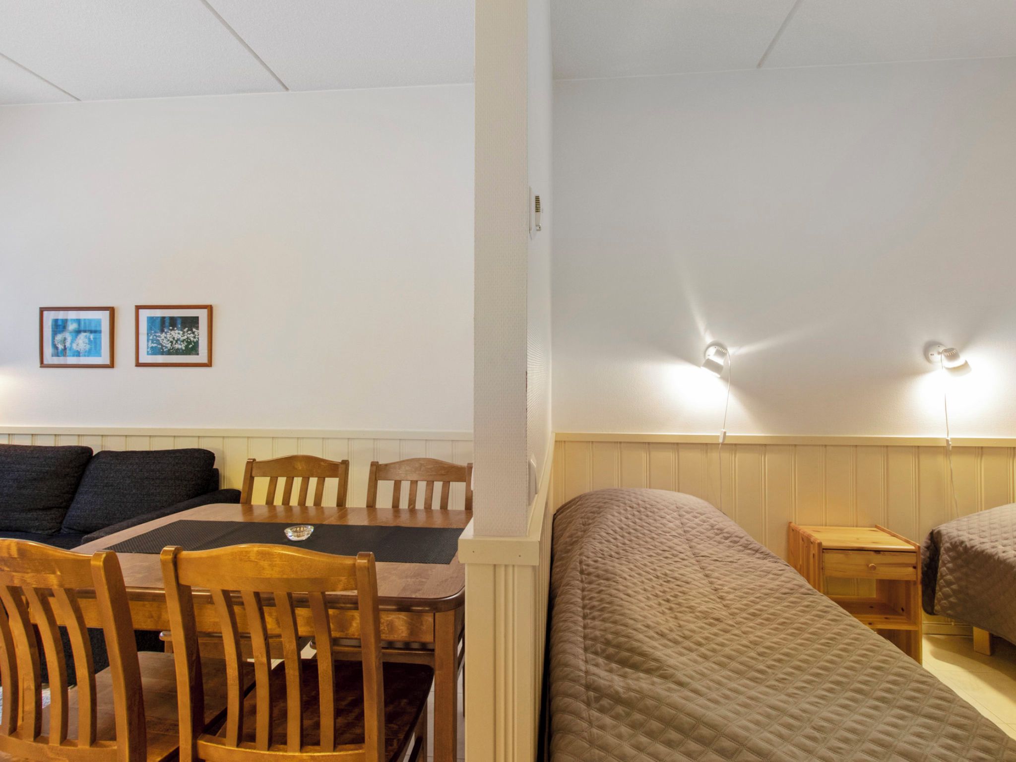 Ein Zimmer mit Esstisch, Stühlen, einer Couch und zwei Betten.
