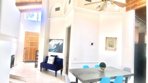 A dining area with a table and chairs, a ceiling fan, and a view of the outside. - Chateau Saguaro is your home away from home (La Quinta)