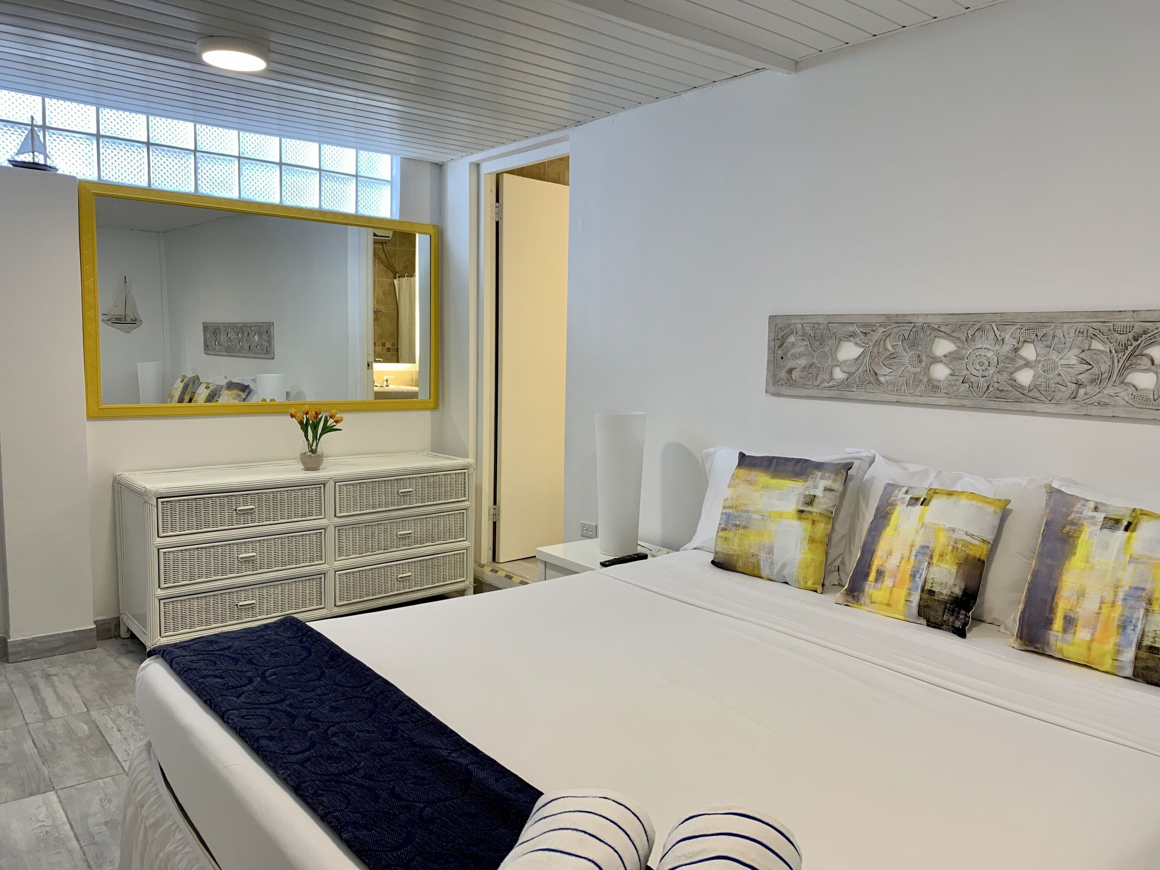 Ein Schlafzimmer mit einem großen Bett, einem Schminktisch, einem Spiegel und einem Wandbild.