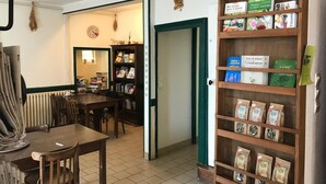 Ein gemütlicher Raum mit Holztisch, Stühlen, einem Bücherregal und einer Tür zu einem anderen Raum.