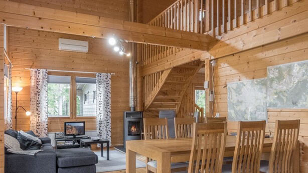 A cozy cabin interior with a living area, dining table, and a fireplace.