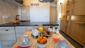 A modern kitchen with a breakfast setup including a fruit bowl, croissants, and a jug of orange juice. - Le Curling B (Val Claret) by Interhome (Tignes)