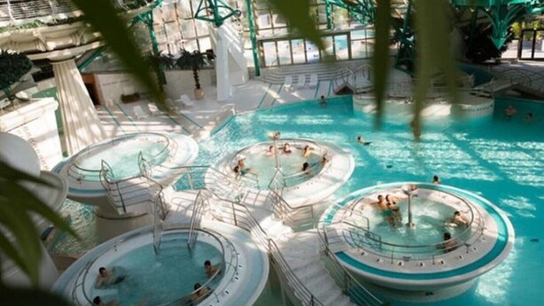 A large indoor swimming pool with multiple circular hot tubs and a central pool area. - Charming T3 "Les Cerdans" 4 seasons 2 people (Porté Puymorens)