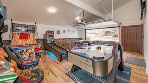 A recreational room with a pool table, foosball table, and a ping pong table.