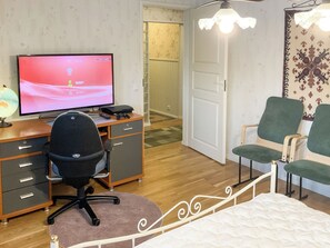 A room with a bed, a desk with a computer, a chair, and a lamp. - Hiawatha by Interhome (Padasjoki)