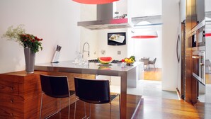 A modern kitchen with a central island, stainless steel appliances, and a large pendant light.