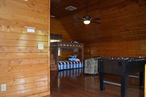 Cozy room with a bunk bed and foosball table, perfect for a fun stay.