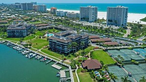 A coastal hotel with multiple buildings, a marina, and tennis courts.