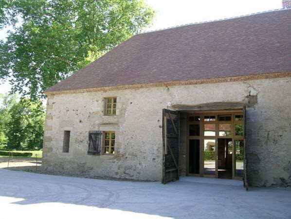 A historic building with a stone facade, a wooden door, and a small window.