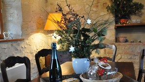 A dining table with a bottle, a Christmas tree, a basket of snacks, and a lamp. - Restored Shepherd's Hut, Pets Allowed (Sauvagny)