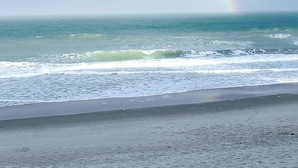A beach with a rainbow over the ocean. - Oceanfront Corner 2BR Condo 2nd Floor Balcony Indian Harbour Beach, Unit 208 (Indian Harbour Beach)