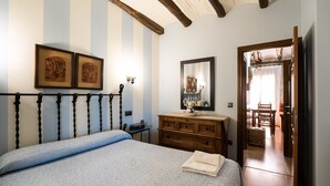 Une chambre à coucher avec un lit, une commode en bois et un miroir.