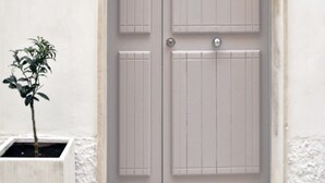 A double door with the number 15 above it, a small potted plant to the left, and a plaque with the text "LA PERPETUA" on the wall. - La Perpetua - The Space of Mima (Noto)