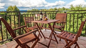 A wooden table and chairs on a balcony with a view of greenery and mountains. - Tre Rose by Interhome (Opatija/Zvoneće)