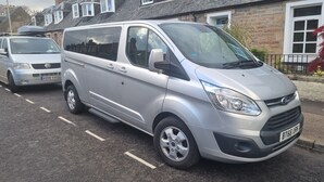 A silver van parked on a residential street.