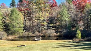 A golf course with a pond and trees in the background.
