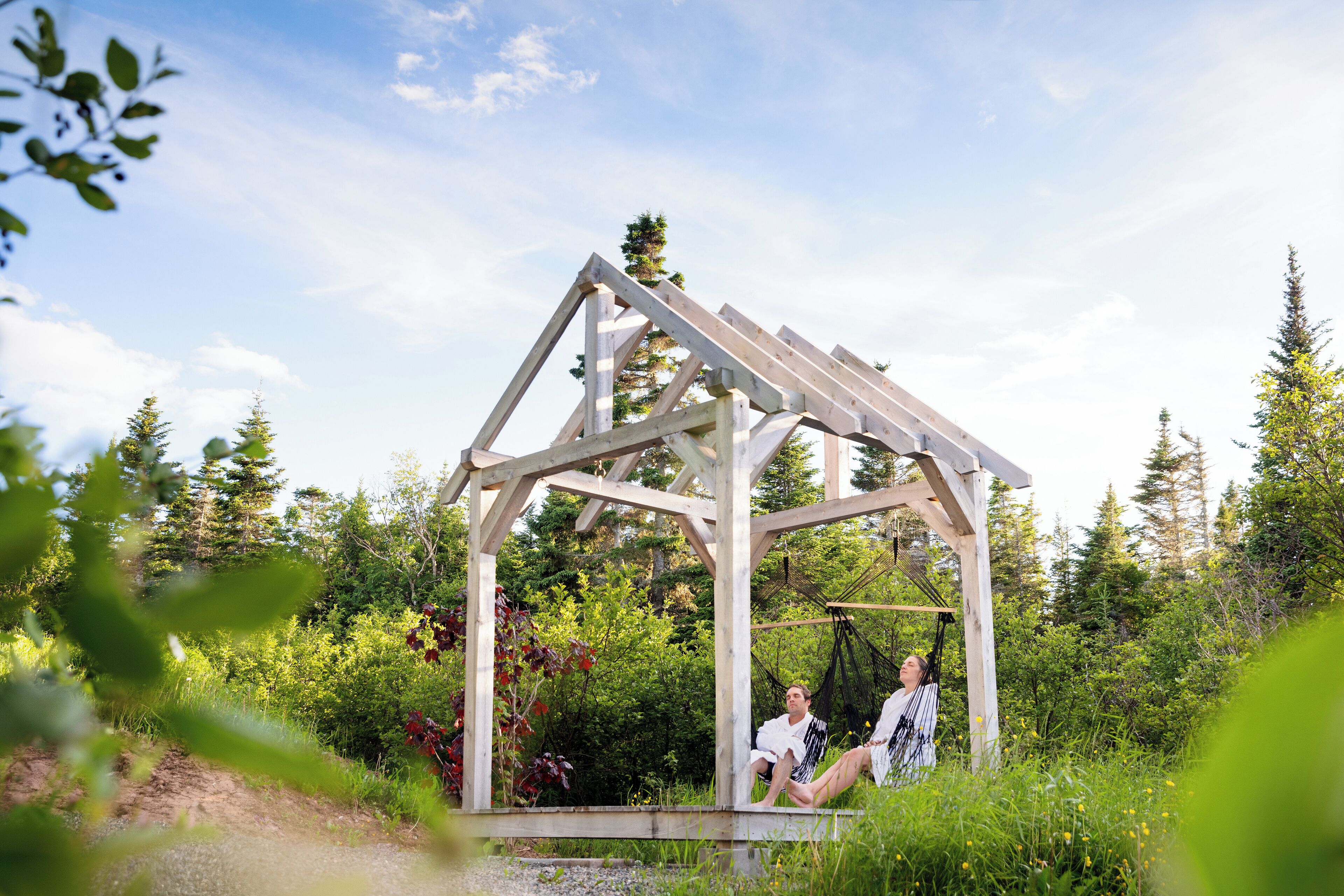 Un kiosque en bois doté d’une structure de toit simple, situé dans un environnement naturel.