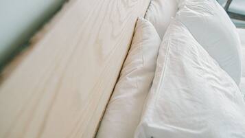 A bed with a wooden headboard and white pillows.