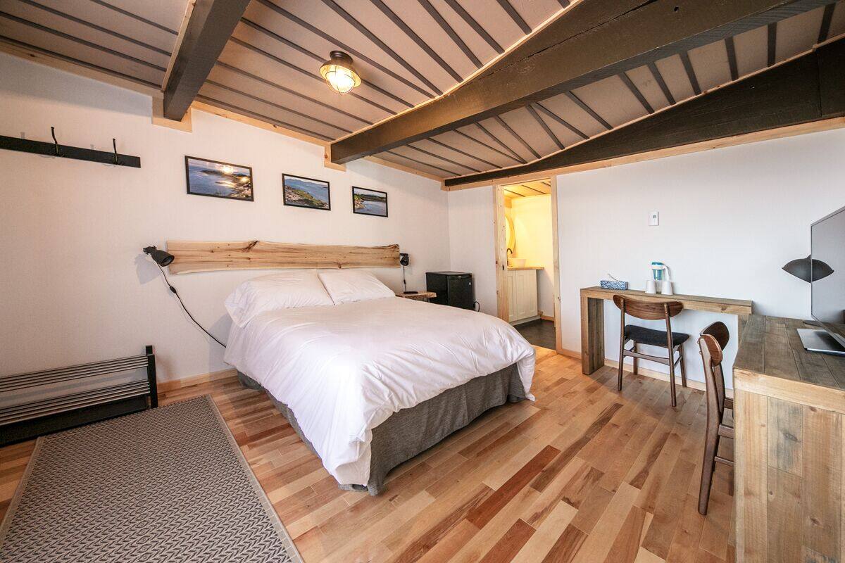 A bedroom with a wooden bed, a desk, and a chair.