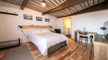 A bedroom with a wooden bed, a desk, and a chair.